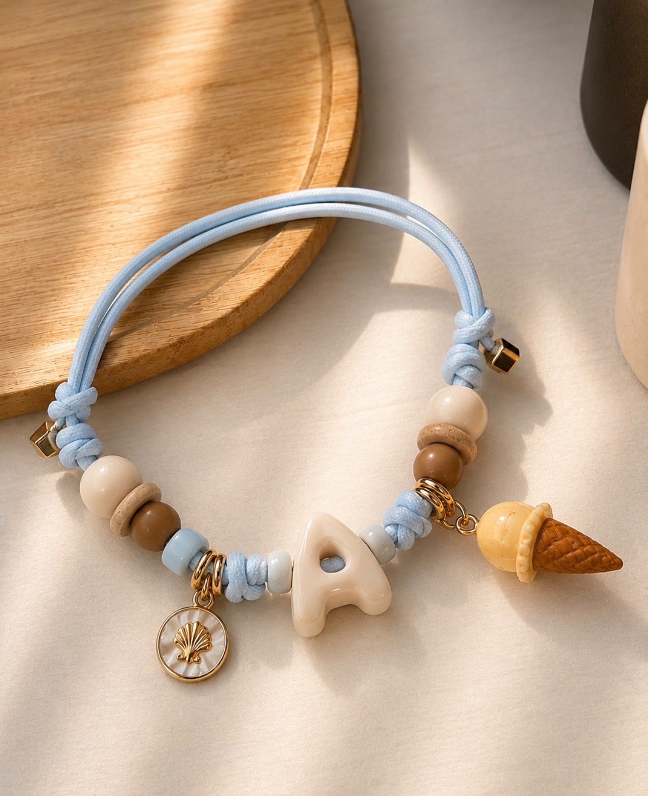 Collanina Essential Charms azzurra con iniziale A e charm gelato.